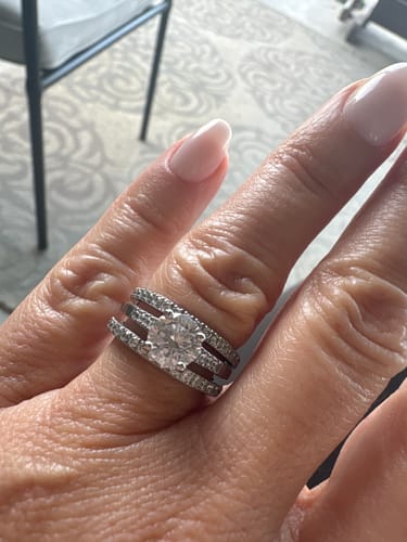 Customer's hand wearing the shiny Round Solitaire Ring stacked with two pave bands.