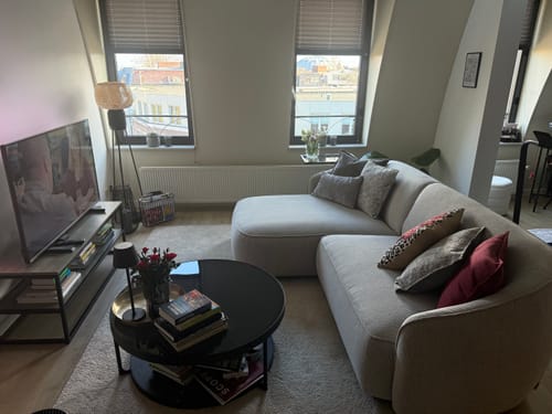 Recensent toont de lichte Chubby hoekbank in een modern ingerichte woonkamer.