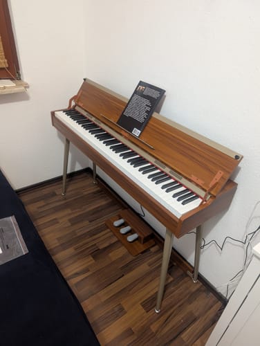 Bewertungsfoto: Das Donner DDP-80 PLUS Digitalpiano in Holzoptik steht in einer Zimmerecke mit geöffnetem Deckel.