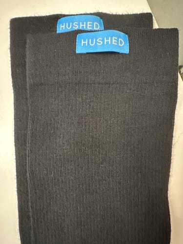 Reviewer's close-up of the black Hushed compression socks, showing the ribbed material.