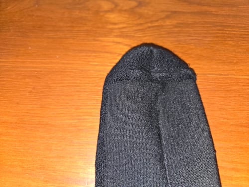 Close-up from a reviewer of the minimal stitching on the toe of the black compression socks.