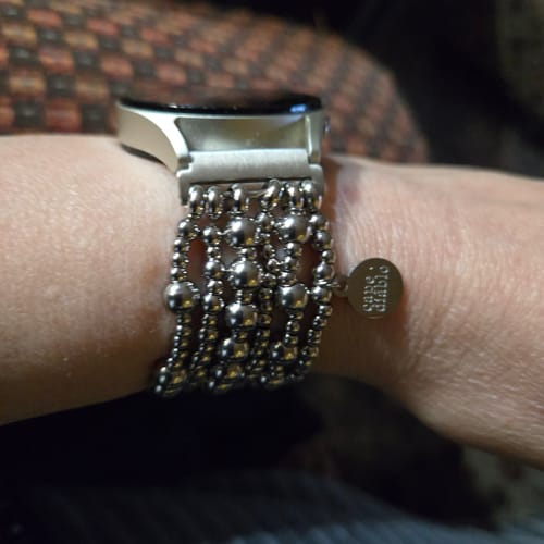 Customer showing the Platinum Demure watch strap on their wrist, featuring multiple strands of silver-colored beads.