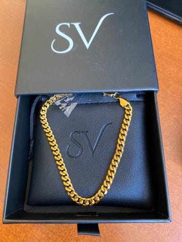 Cliente mostrando la brillante Pulsera Miami Cuban en su caja de presentación negra.