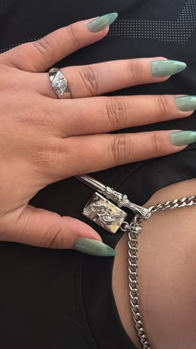 Close-up of a reviewer's hand holding the silver Scorpio Tarot Card Pendant on a chain.