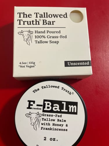Customer's Unscented The Tallowed Truth Bar in its box, shown with a tin of tallow balm on a red background.