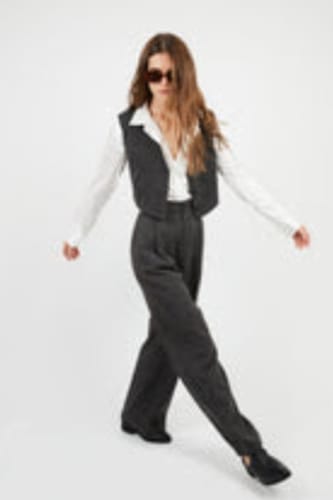 Una clienta muestra el pantalón VALERIA marengo como parte de un elegante conjunto de invierno.