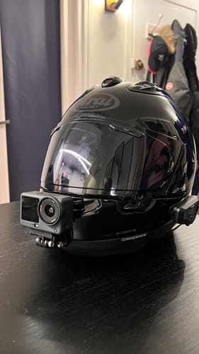 Customer's camera mount shown perfectly fitted to a black Arai helmet with a DJI action camera attached.