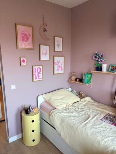 Klant toont de gele Kartell Componibili-kast als nachtkastje in een slaapkamer met oudroze muren.