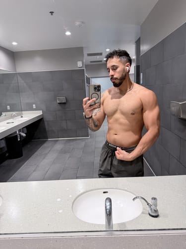Customer's mirror selfie showing a muscular physique with visible abs after using the Hydroxygenin fat burner for two weeks.