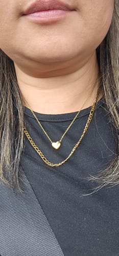 Customer wearing the gold Riley Heart Necklace, layered with another chain from the bundle.
