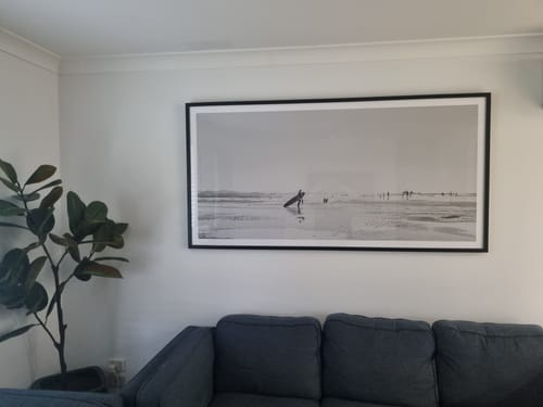 Customer's large Summer Days, Wategos B&W panoramic print in a black frame, displayed on a wall above a sofa.