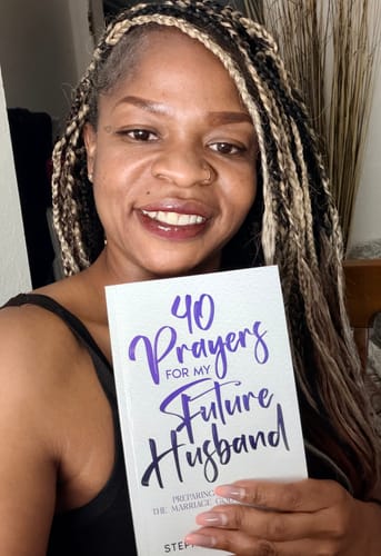 Reviewer smiling while holding her copy of the "40 Prayers for My Future Husband" book.