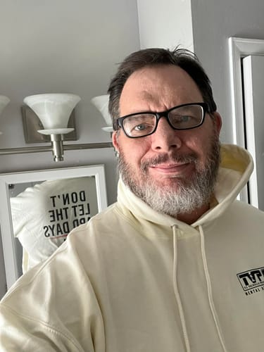 Customer smiling in a selfie while wearing a cream-colored Hard Days - Hoodie.