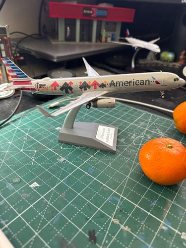 Reviewer's American A321 'Stand Up to Cancer' model airplane displayed on its stand on a desk.