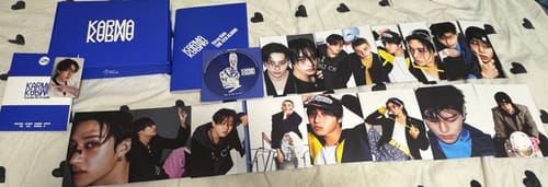 Customer displays the contents of their random K-pop album, including the blue box, photobook, CD, and many photocards.