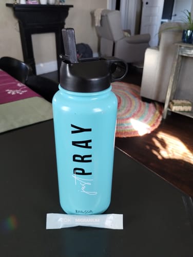 Customer's single Migranium sachet on a table next to a light blue water bottle, ready for mixing.