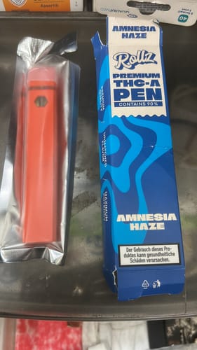 Customer's red ROLLZ THCA Vape pen in its wrapper, next to the blue and white 'Amnesia Haze' box.