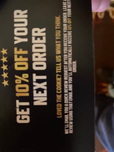 Customer's photo of a promotional card from Cael's Cookie offering 10% off the next order for leaving a review.