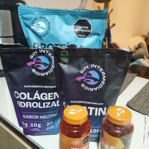 Cliente muestra su Proteína Aislada ISO azul junto a otros suplementos de la marca.