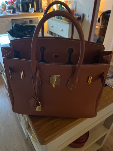 Customer's brown leather Warkin Bag (35cm size) sitting open on a wooden table in a home.