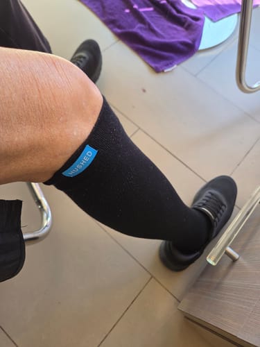Customer wearing a black Performance Eucalyptus Compression Sock, pulled up to just below the knee.