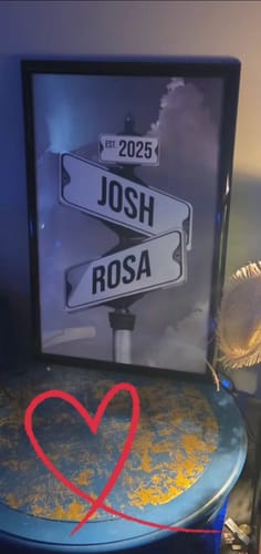 Customer's framed 'Couples Date of Love' canvas personalized with street signs for 'Josh' and 'Rosa' and the date 'Est. 2025'.