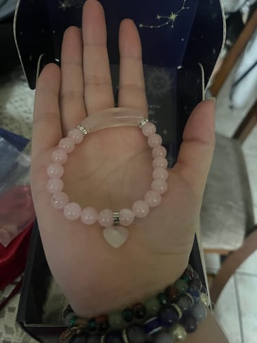 Reviewer holding a pink beaded crystal bracelet with a heart charm from their VIP Crystal Club box.