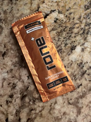 Reviewer's shiny packet of Classic 200mg Caffeine SuperCharged Honey on a countertop.