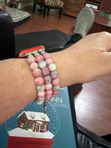 Close-up of a reviewer wearing a pink and grey beaded Apple Watch strap.