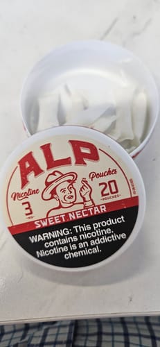 Customer's open white tin of Sweet Nectar Nicotine Pouches with the lid beside it, showing pouches inside.