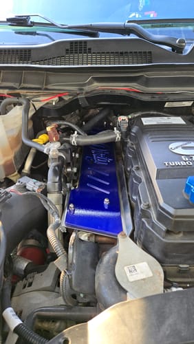 Customer's blue Cummins Exhaust Manifold Heat Shield installed in a truck's engine bay.
