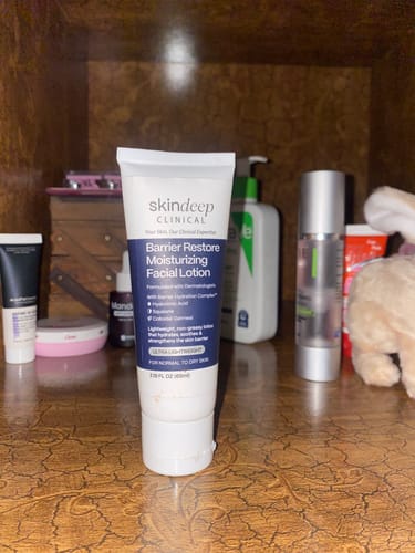 Customer's Barrier Restore Moisturizing Facial Lotion standing on a wooden shelf with other products.