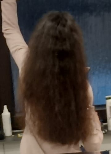 Kundin zeigt von hinten ihr langes, fülliges Haar nach der Anwendung der Apple-Wonder Haarseife.