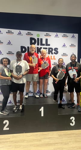 Reviewer standing on a first-place podium at a pickleball tournament wearing MUUV Flow Pickleball Shoes.