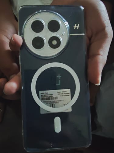 Customer holding a dark phone with the clear Anti Yellow Magsafe case, showing the white magnetic ring on the back.