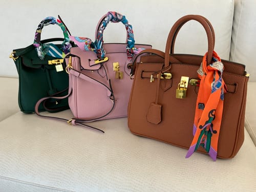 Customer's three Warkin Bags in dark green, pink, and brown, shown sitting together on a light-colored sofa.
