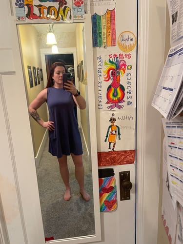 Reviewer in a mirror selfie wearing the blue A-line Clara Dress, showing its flattering fit.