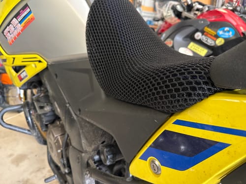 Close-up of a customer's black Wind Rider Seat Cover with its honeycomb texture, fitted on a yellow and grey motorcycle seat.