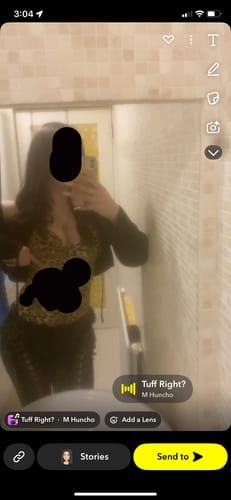 Reviewer takes a mirror selfie wearing the black denim LOW RISERS pants with a leopard print top.