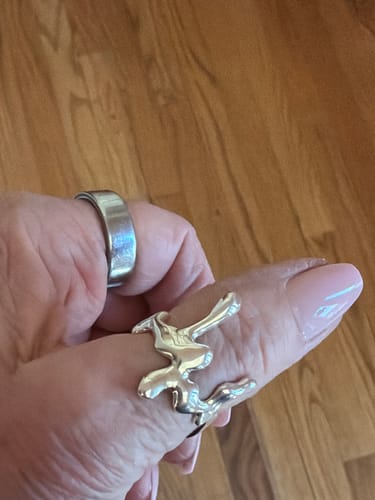 Customer's hand wearing the shiny silver Liquid Ring with its unique dripping design.