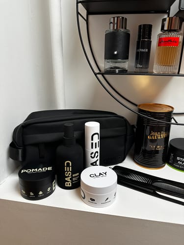 Reviewer's Complete Styling Kit, including pomade, clay, and spray, arranged on a white shelf.