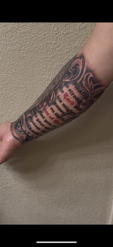 Reviewer's arm showing a finished black and grey tattoo with script, completed with help from the numbing product.