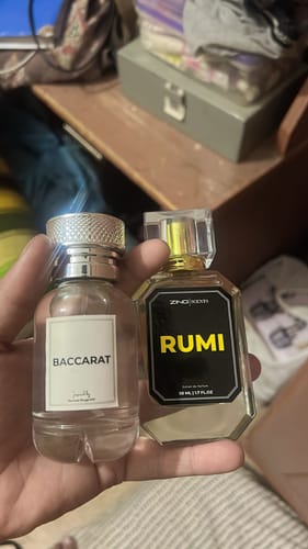 Customer holding a clear BACCARAT perfume bottle next to another fragrance bottle.