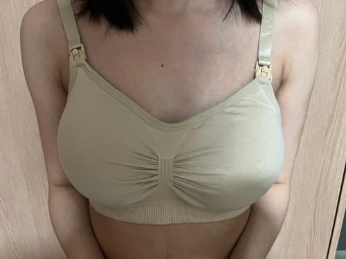 A front view of a reviewer wearing the beige Lovemère Seamless Nursing Bra, showing the seamless cups and nursing clips.