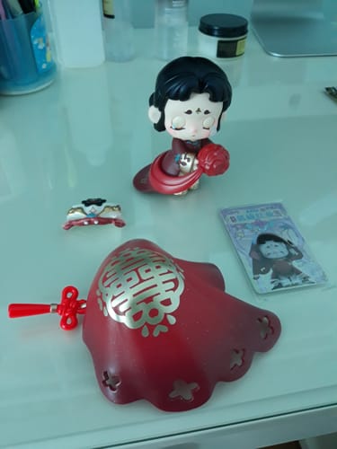 Reviewer's Kasa Marvelous Stories figure with its separate red veil, mask, and ID card laid out on a table.