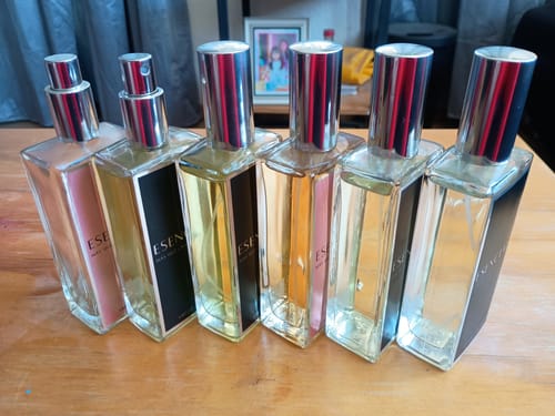 La colección de un cliente de seis perfumes ESENCIAL, alineados sobre una mesa de madera.