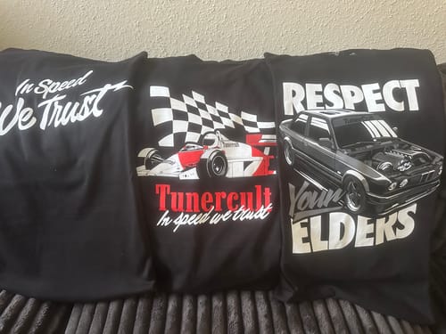 Customer's three black graphic t-shirts from the MYSTERY CASH BOX, featuring assorted car-themed designs.