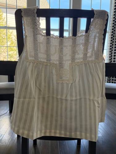 Customer's Lucky Top with its crocheted upper and striped body, displayed on the back of a chair.