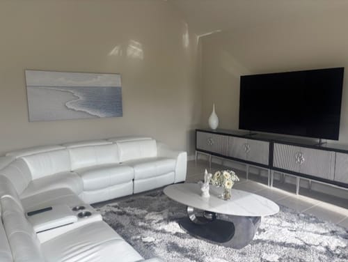Reviewer's Abstract Beach Shore Wall Art hanging above a large white sofa in a living room.