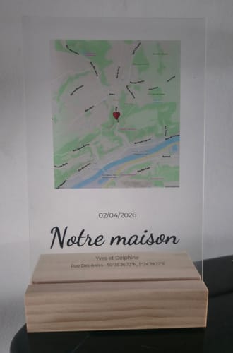 Personalisierte Acrylplatte eines Kunden mit einer Karte und dem Text „Notre maison“, die in einem Holzsockel steht.